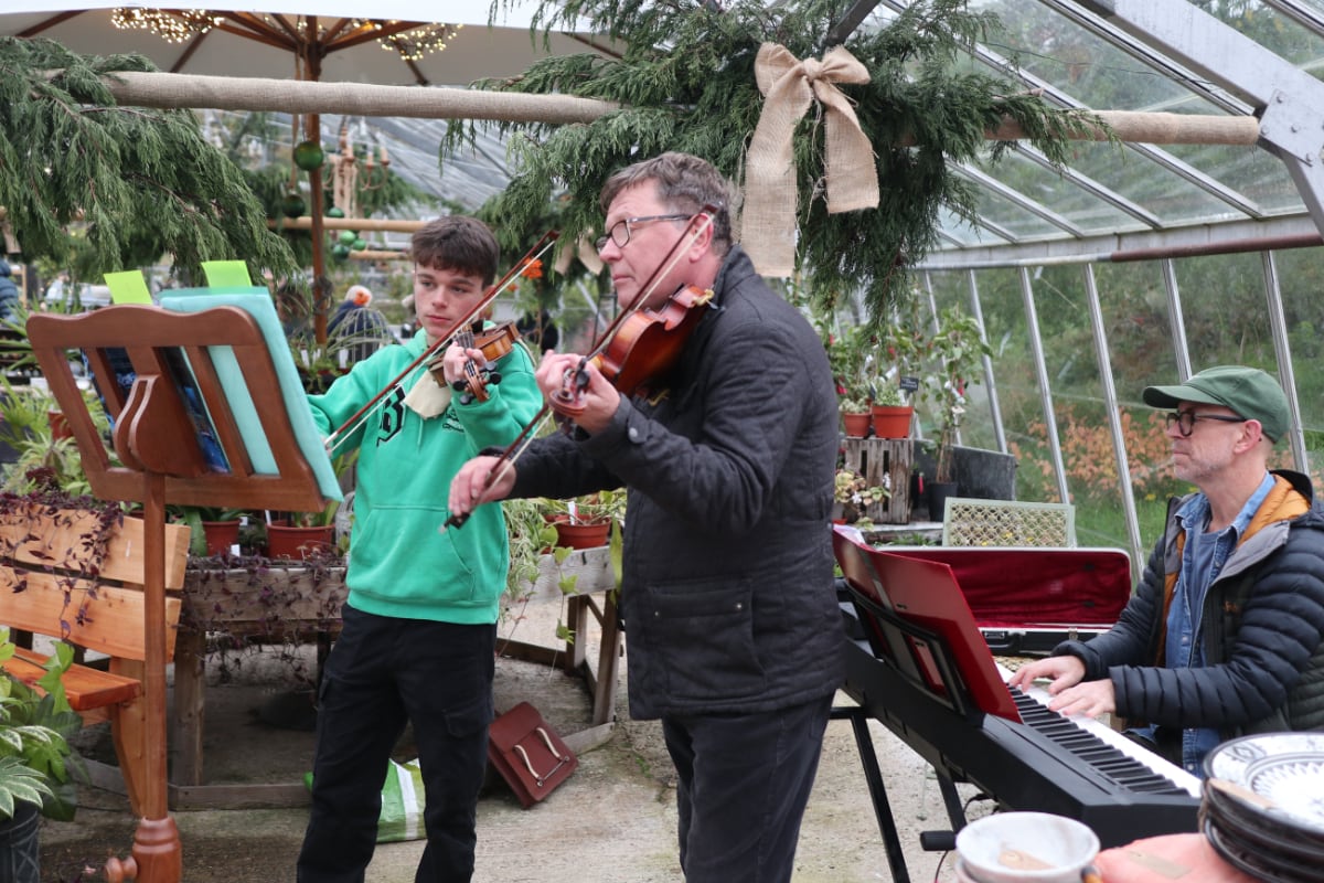 The violin and piano trio playing music in the Greenhouse at the Christmas Market.