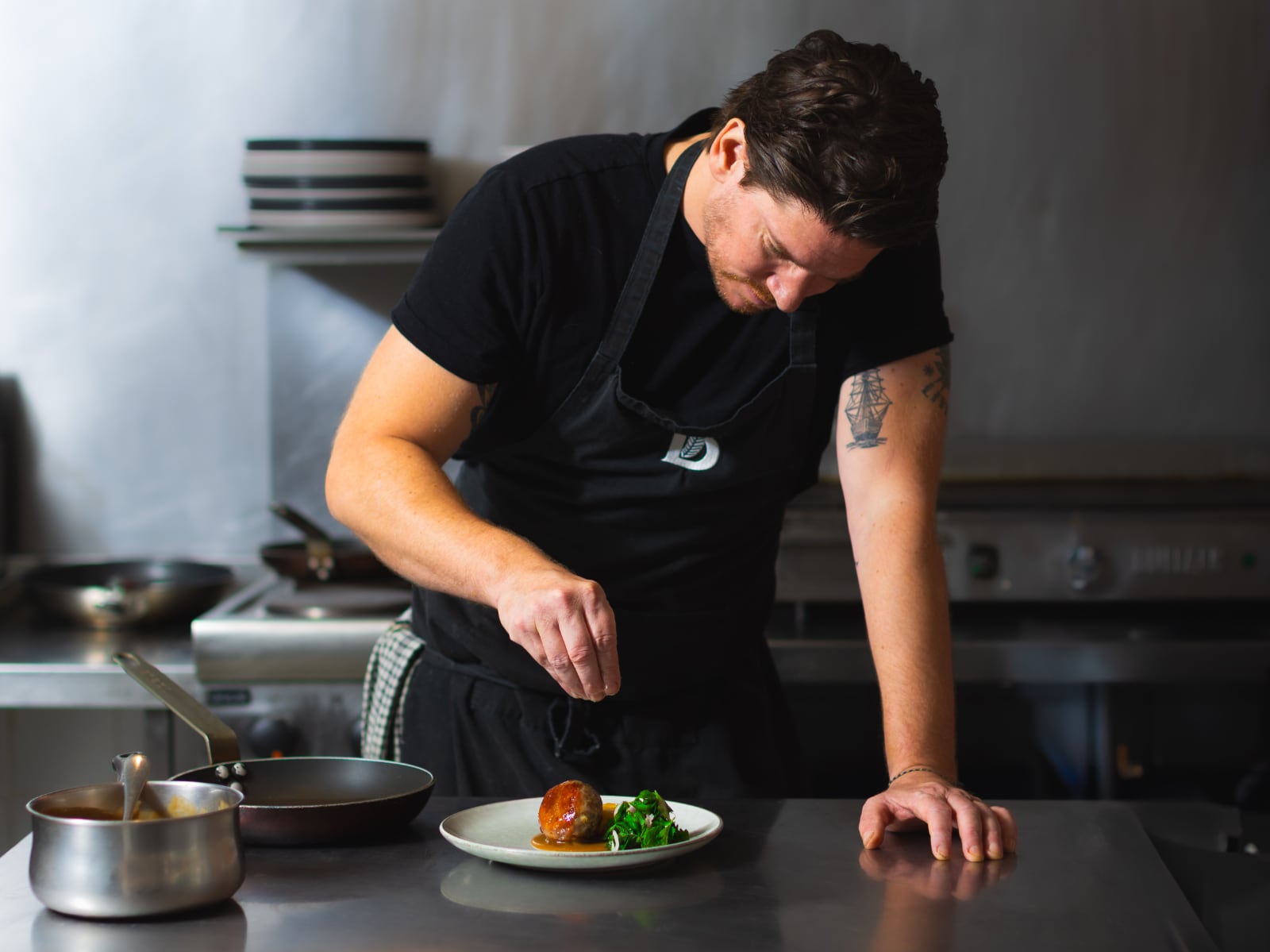 Chef Alex putting the finishing touches to a plate of delicious food.