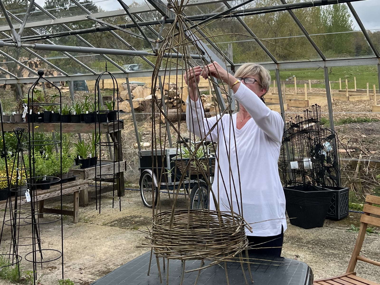 Woman creating a garden obelisk in the greenhouse at Babylon.